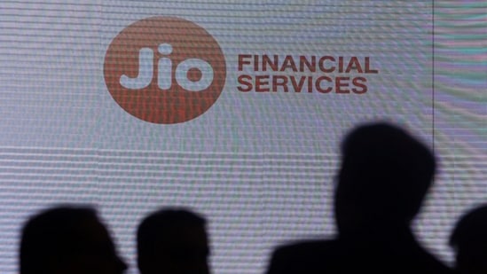 People stand next to a logo of Jio Financial Services.(REUTERS)