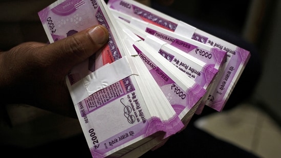 A cashier displays the new 2000 Indian rupee banknotes inside a bank in Jammu.(REUTERS)