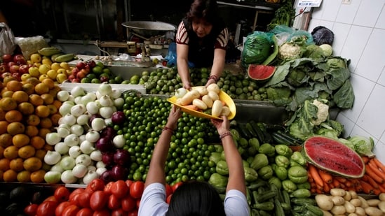 A woman buys vegetables at a market(REUTERS)