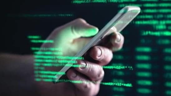 Darkweb, darknet and hacking concept. Hacker with cellphone. Man using dark web with smartphone. Mobile phone fraud, online scam and cyber security threat. Scammer using stolen cell. AR data code. (Shutterstock)