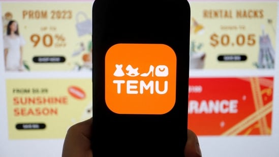 The logo of Temu, an e-commerce platform owned by PDD Holdings, is seen on a mobile phone displayed in front of its website.(REUTERS)