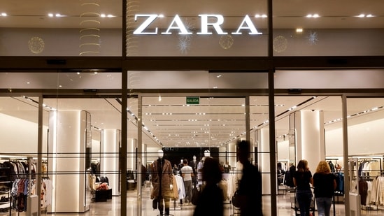 Shoppers walk past a Zara clothes store(REUTERS)