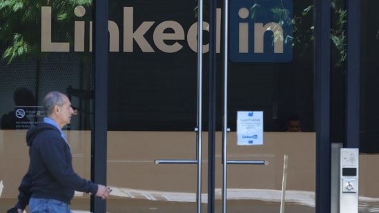 A pedestrian walks by a sign at a LinkedIn office(Getty Images via AFP)