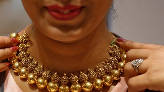 FILE PHOTO: A saleswoman displays a gold necklace to a customer inside a jewellery showroom on the occasion of Akshaya Tritiya, a major gold buying festival, in Mumbai, India April 18, 2018. REUTERS/Francis Mascarenhas/File Photo