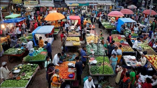 FILE PHOTO: Customers buy fruits and vegetables at an open air evening market in Ahmedabad (REUTERS)