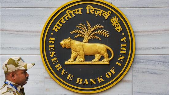 A security official walks past an emblem of the Reserve Bank of India at the RBI headquarters, in Mumbai (PTI FILE)