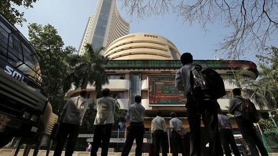 People look at a screen displaying the Sensex results on the facade of the Bombay Stock Exchange (BSE) building in Mumbai.(REUTERS)