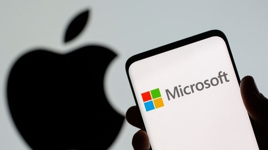 Microsoft logo is seen on the smartphone in front of displayed Apple logo in this illustration taken.(REUTERS)