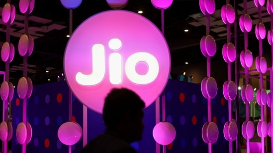 A man walks across the LED board showing the logo of Jio at India Mobile Congress 2022, at Pragati Maidan, in New Delhi, India, October 3, 2022. (REUTERS)