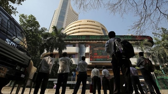 People look at a screen displaying the Sensex results on the facade of the Bombay Stock Exchange (BSE) building in Mumbai.(REUTERS)