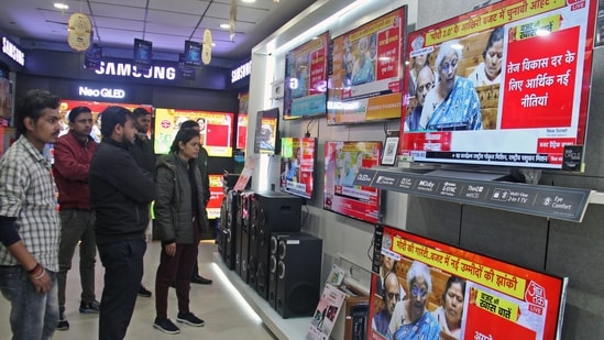 People watch the live telecast of the interim budget 2024 by Union finance minister Nirmala Sitharaman, at a showroom in Gurugram, on Thursday. (ANI)
