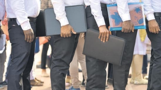 Candidates stand in a row at a job fair.(HT File)