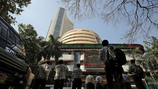 People look at a screen displaying the Sensex results on the facade of the Bombay Stock Exchange (BSE) building in Mumbai.(REUTERS)