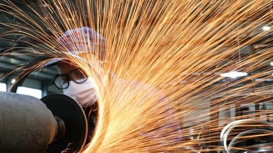 A worker wearing a face mask works on a production line manufacturing.(Reuters/ File photo)