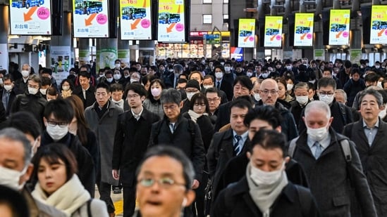 Commuters walk through Shinagawa Station during the morning rush hour in Tokyo.(AFP)