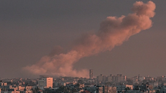 A picture taken from Rafah in the southern Gaza Strip shows smoke rising over buildings in Khan Yunis.(AFP)