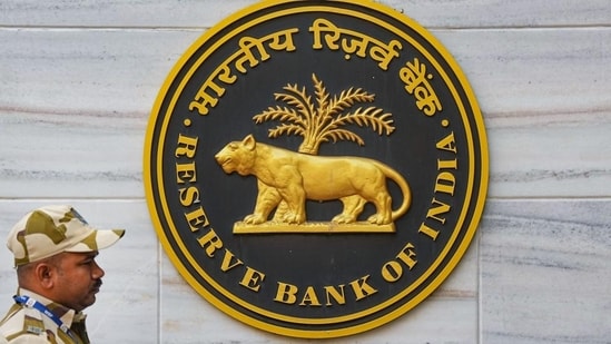 A security official walks past an emblem of the Reserve Bank of India at the RBI headquarters, in Mumbai (PTI FILE)