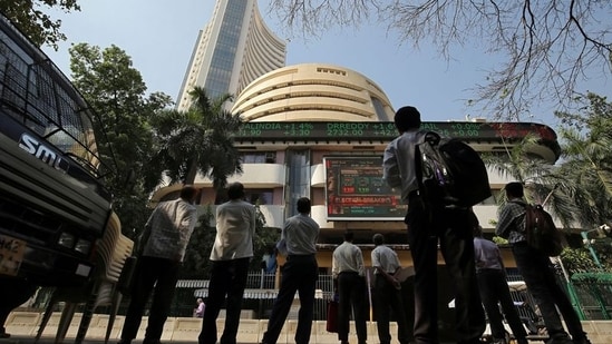 People look at a screen displaying the Sensex results on the facade of the Bombay Stock Exchange (BSE) building in Mumbai.(REUTERS)