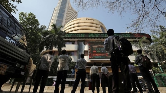 People look at a screen displaying the Sensex results on the facade of the Bombay Stock Exchange (BSE) building in Mumbai.(REUTERS)