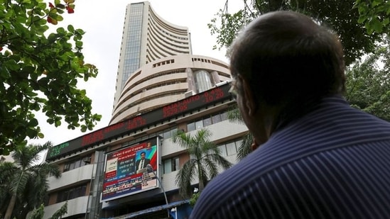 A man looks at a screen across a road displaying the Sensex on the facade of the Bombay Stock Exchange (BSE) building in Mumbai.(REUTERS)